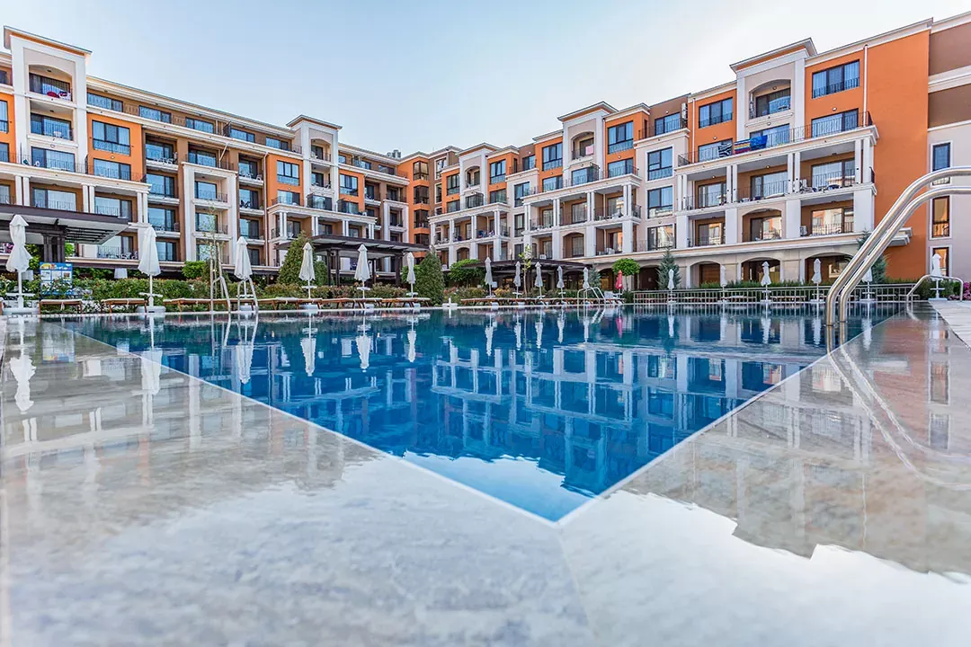Basen w kompleksie Premier Fort Beach z odbiciem budynków